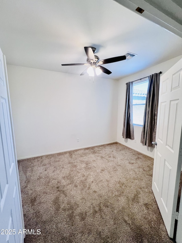 unfurnished bedroom featuring baseboards, visible vents, carpet floors, and ceiling fan