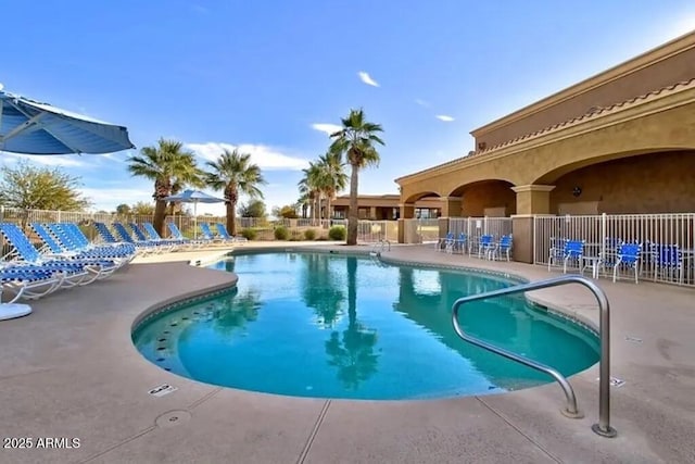 community pool with a patio and fence