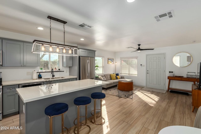 kitchen featuring decorative light fixtures, stainless steel refrigerator, ceiling fan, and plenty of natural light