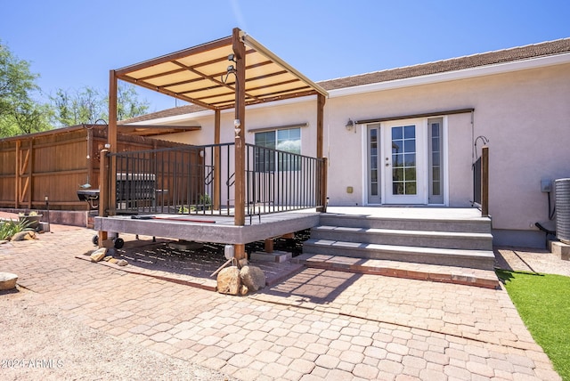 rear view of house featuring a wooden deck and a patio