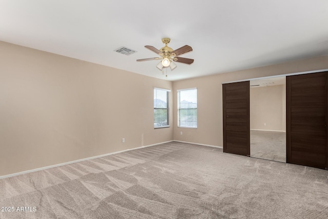 unfurnished bedroom with ceiling fan, a closet, and light carpet