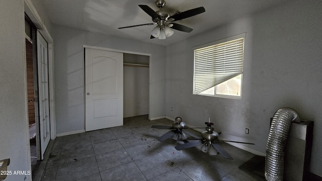 unfurnished bedroom featuring ceiling fan, a closet, and baseboards