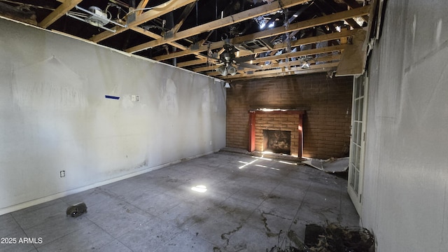unfurnished living room with baseboards and a brick fireplace