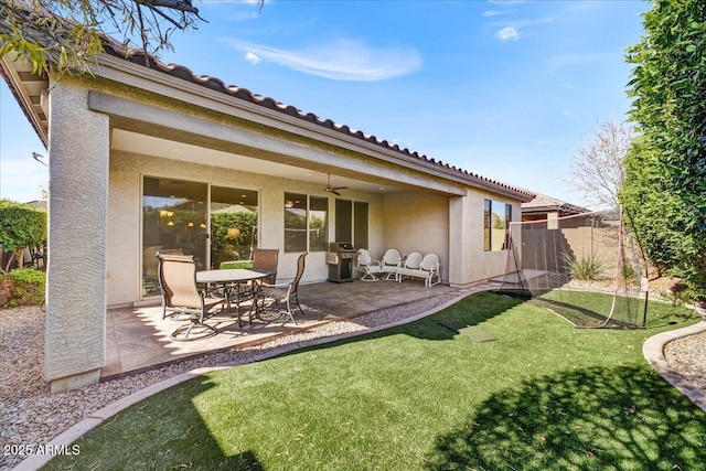 back of house featuring ceiling fan, a lawn, and a patio area