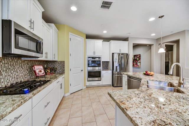 kitchen featuring sink, stainless steel appliances, white cabinetry, and decorative backsplash