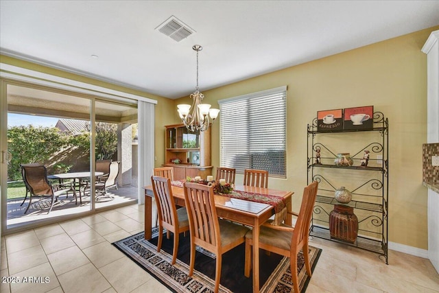 dining area featuring an inviting chandelier, light tile patterned flooring, and a healthy amount of sunlight