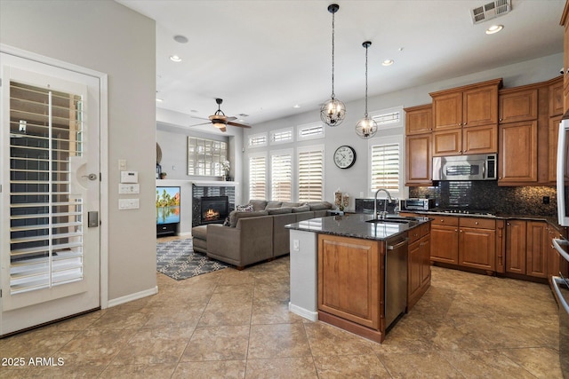 9262 E Desert Park Dr, Scottsdale, AZ 85255 - kitchen featuring appliances with stainless steel finishes, brown cabinetry, ceiling fan, a center island with sink, and recessed lighting
