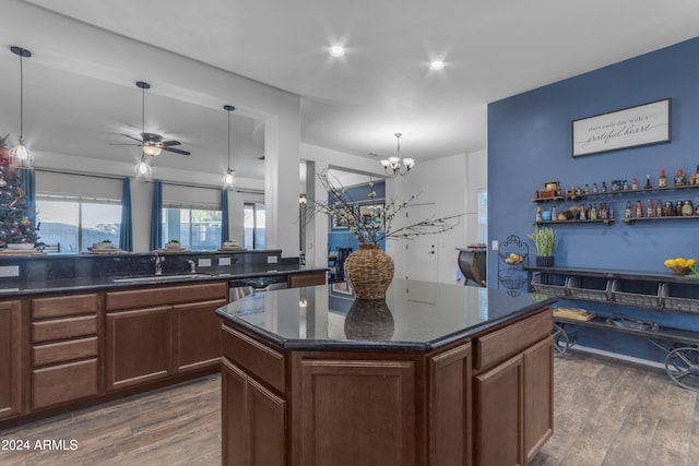 kitchen featuring pendant lighting, a center island, sink, stainless steel dishwasher, and dark hardwood / wood-style floors