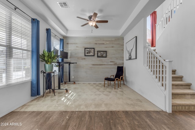 sitting room featuring plenty of natural light, wood-type flooring, and wooden walls