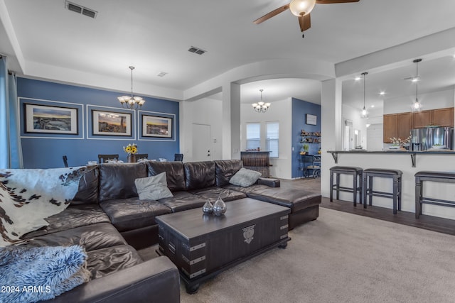 living room with carpet flooring and ceiling fan with notable chandelier