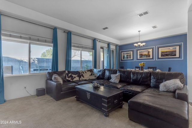 carpeted living room with a notable chandelier