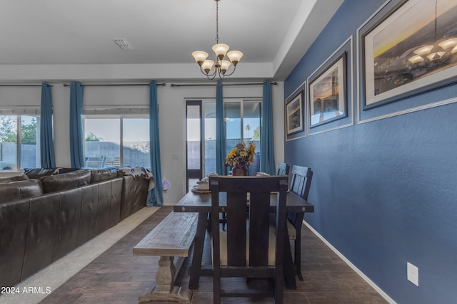 dining area with a mountain view, an inviting chandelier, and dark wood-type flooring