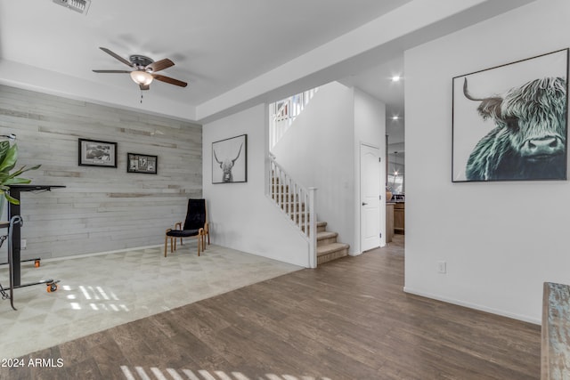 unfurnished room with ceiling fan, wood-type flooring, and wood walls