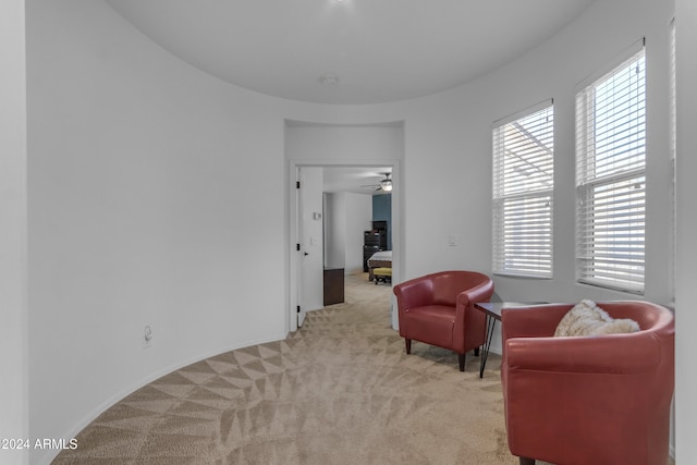 living area with plenty of natural light, ceiling fan, and light carpet