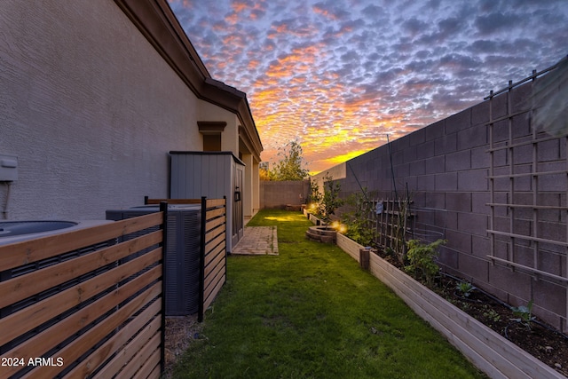 yard at dusk with central air condition unit