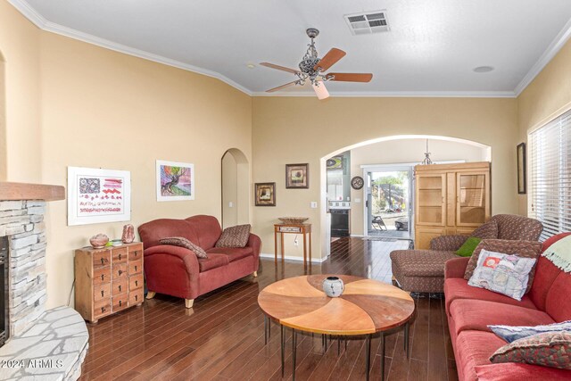 living room featuring a fireplace, crown molding, dark hardwood / wood-style flooring, and plenty of natural light