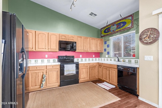 kitchen with tile counters, sink, black appliances, and light brown cabinets