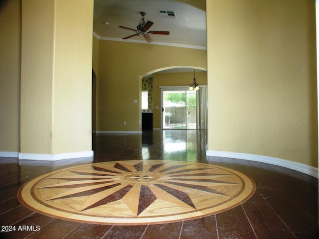 interior space with ceiling fan and crown molding