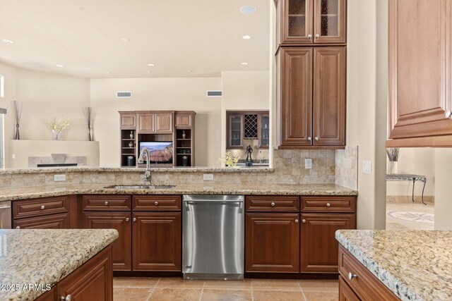 kitchen with light stone counters, visible vents, a sink, stainless steel dishwasher, and backsplash