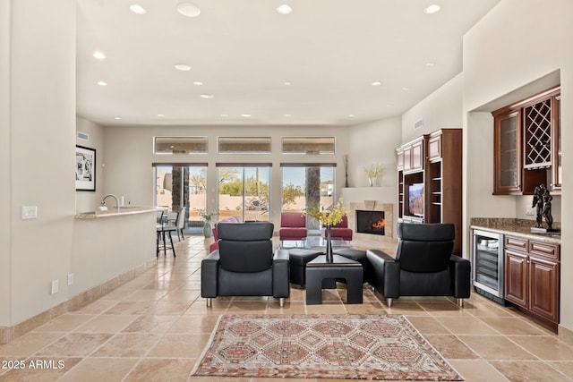 living room with wine cooler, recessed lighting, a fireplace, and indoor wet bar