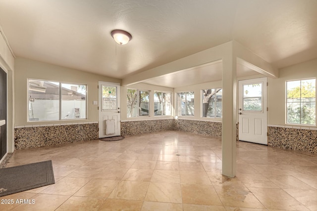 unfurnished sunroom featuring lofted ceiling