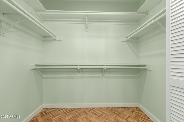 walk in closet with light parquet flooring