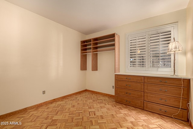 unfurnished bedroom featuring light parquet floors and a closet