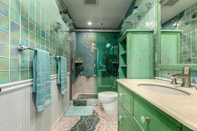 bathroom featuring tile patterned floors, vanity, toilet, and a shower with shower door