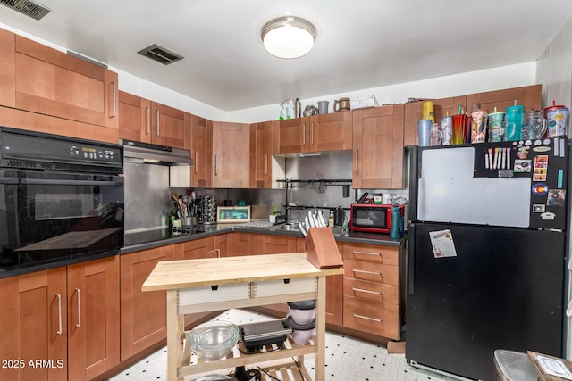 2801 W Glenrosa Ave, Phoenix, AZ 85017 - kitchen with black appliances, under cabinet range hood, light flooring, and dark countertops