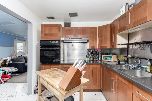 2801 W Glenrosa Ave, Phoenix, AZ 85017 - kitchen with black appliances, under cabinet range hood, a sink, light flooring, and dark countertops