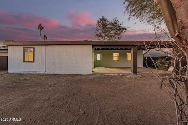 back house at dusk with a patio