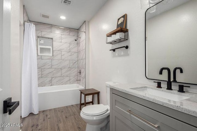 bathroom with toilet, visible vents, wood finished floors, and vanity