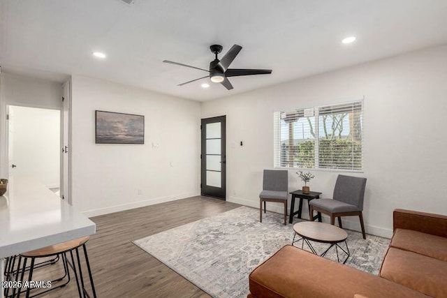 sitting room with baseboards, wood finished floors, and recessed lighting