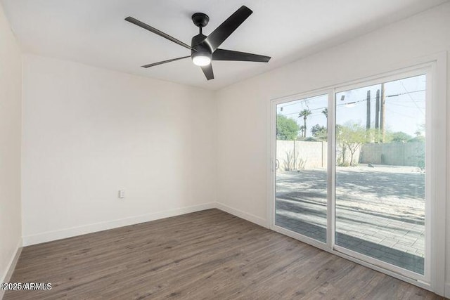 spare room with ceiling fan, wood finished floors, and baseboards