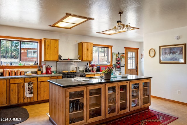 1528 Black Canyon Rd, Heber, AZ 85928 - kitchen with brown cabinets, stove, a ceiling fan, light wood-style flooring, and a sink