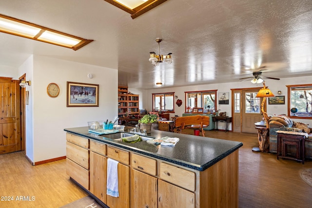 1528 Black Canyon Rd, Heber, AZ 85928 - kitchen with a sink, open floor plan, dark countertops, and light wood finished floors