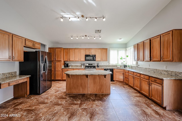 kitchen featuring sink, light stone counters, lofted ceiling, black appliances, and a center island