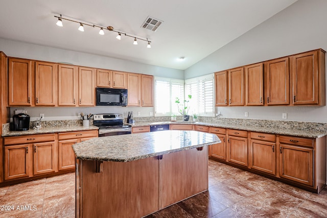 kitchen with light stone counters, lofted ceiling, black appliances, a center island, and a kitchen bar