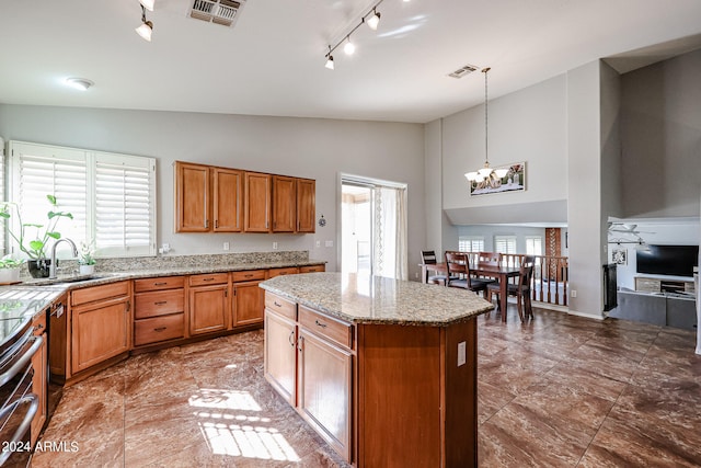 kitchen featuring pendant lighting, a healthy amount of sunlight, a kitchen island, and rail lighting