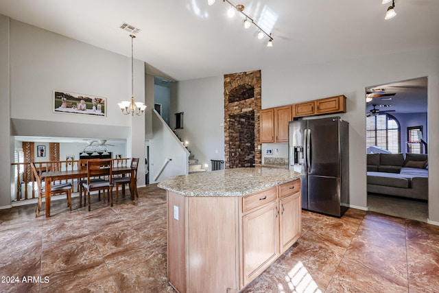 kitchen featuring a kitchen island, rail lighting, ceiling fan with notable chandelier, hanging light fixtures, and stainless steel fridge with ice dispenser