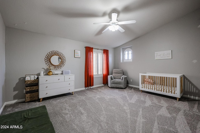 unfurnished bedroom featuring lofted ceiling, a nursery area, ceiling fan, and carpet floors