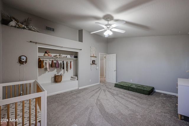 unfurnished bedroom with ceiling fan, a nursery area, a closet, and carpet