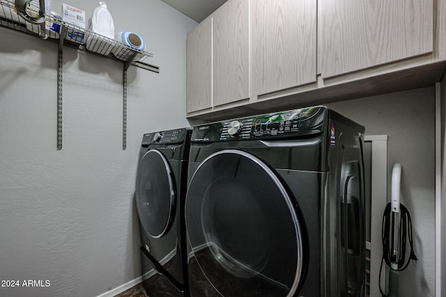 laundry room with washer and dryer and cabinets