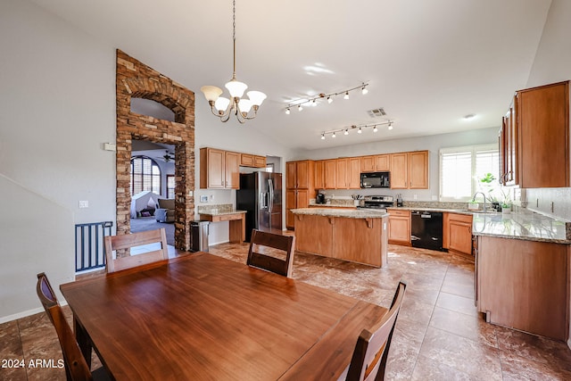 dining room featuring lofted ceiling, ceiling fan with notable chandelier, and sink