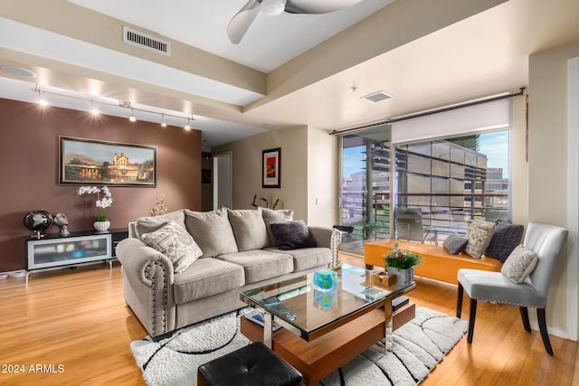 living room featuring wood-type flooring, rail lighting, and ceiling fan