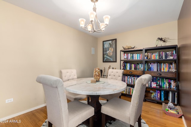 dining space with a notable chandelier and light hardwood / wood-style floors