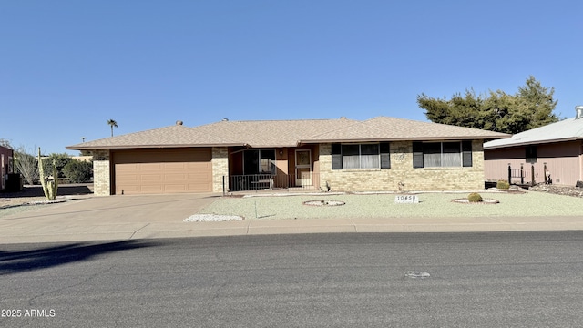 single story home with a garage, concrete driveway, brick siding, and a shingled roof