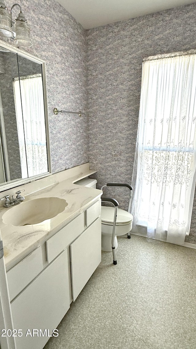 bathroom with toilet, a healthy amount of sunlight, and vanity