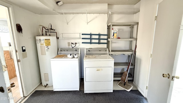 washroom with laundry area, water heater, baseboards, and washing machine and clothes dryer