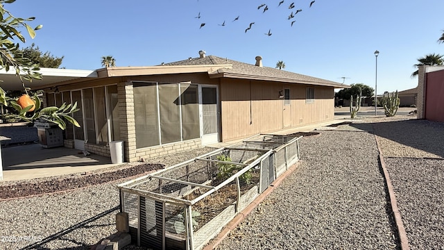 exterior space with a patio area and a vegetable garden